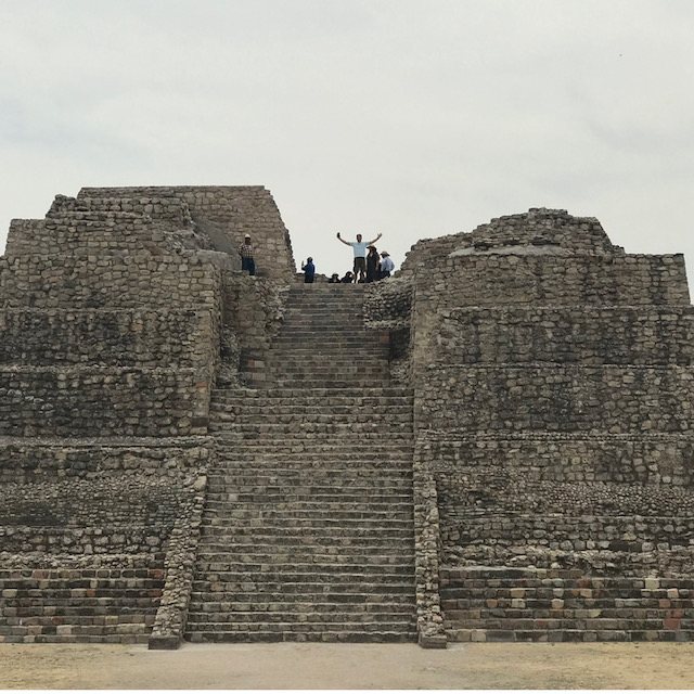 Alfred with arms raised at the top of the pyramid at Cañada de la Virgen